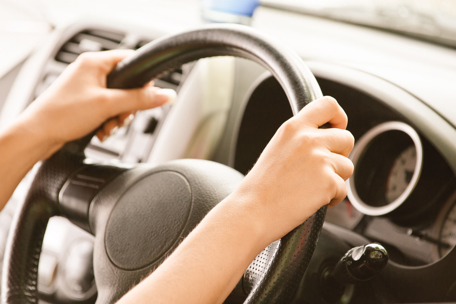 Learner holding a steering wheel during a driving lesson