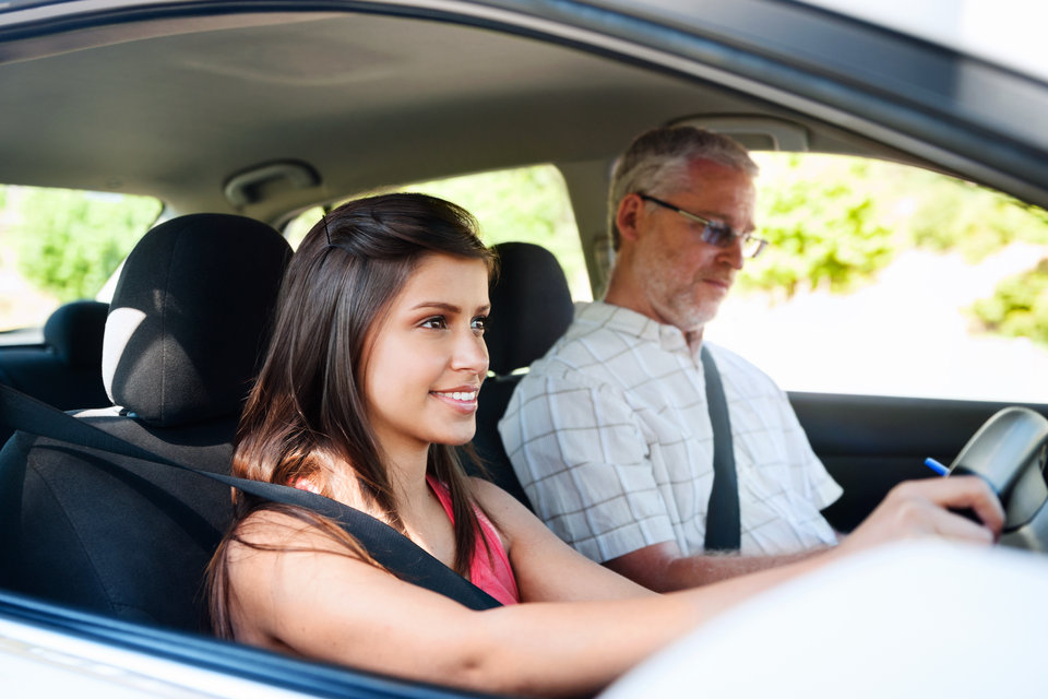 Learner driver receiving guidance from an instructor inside a car