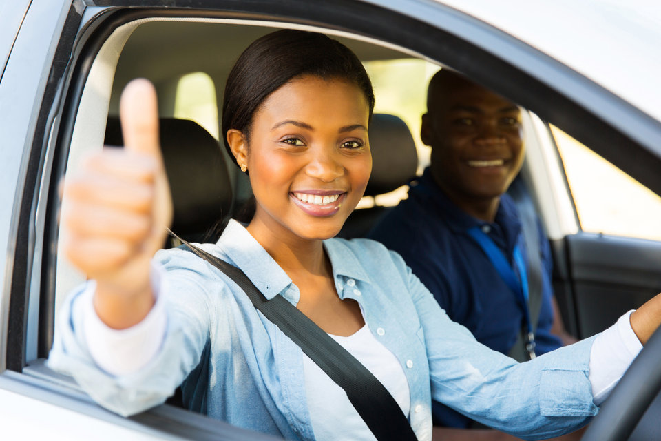A successful learner driver smiling with her instructor